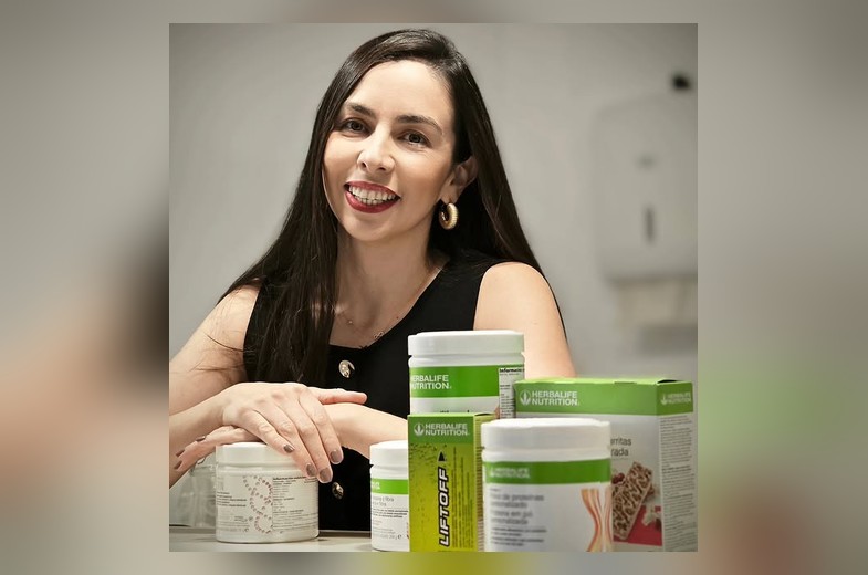 Laura Morales sonriendo junto a productos de nutrición